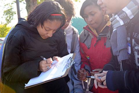 A young woman filling something out on a clipboard